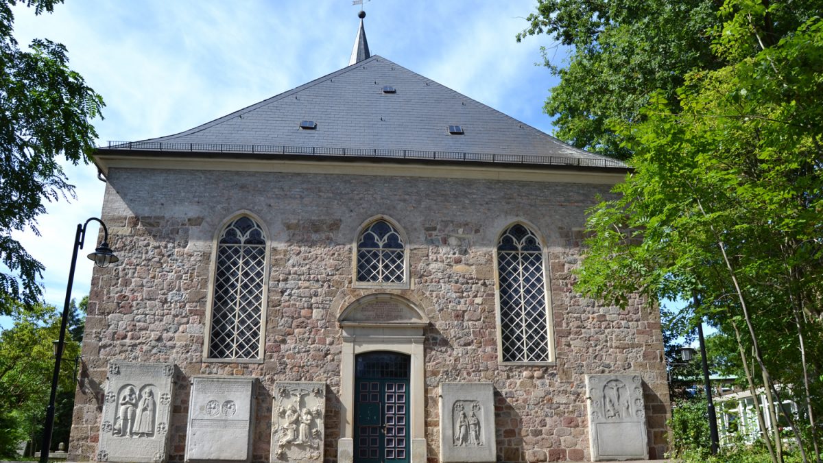 Ein großes Kirchengebäude mit Bäumen rechts und links.