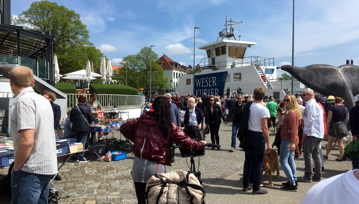 Menschen schlendern in Vegesack entlang der Weserpromenade. Es sind Flohmarktstände aufgebaut