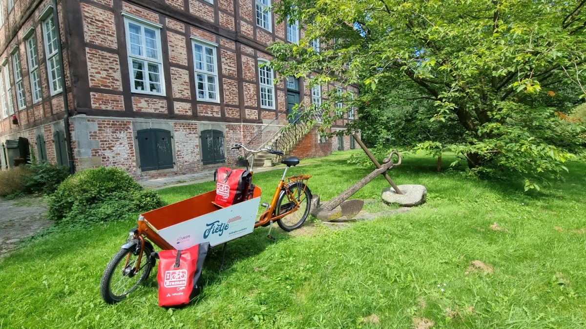 Ein rotes Lastenrad steht vor dem Schloss Schönebeck